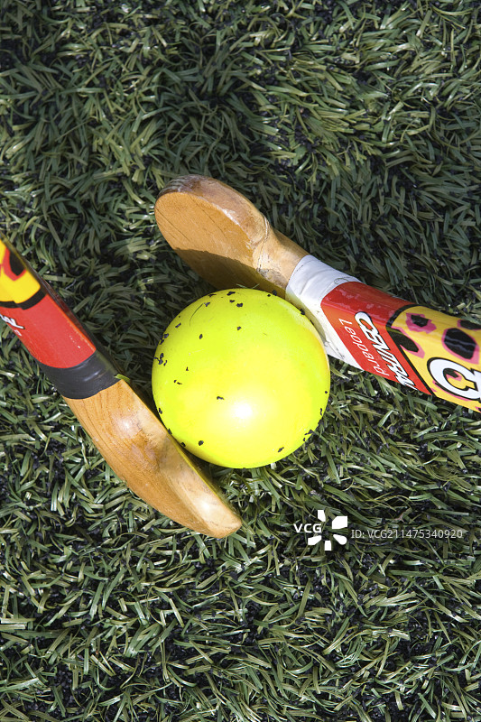 两根曲棍球棒争夺一个球图片素材