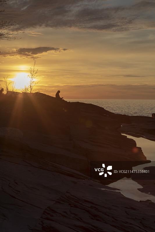 男人在日落时分在湖边读书图片素材