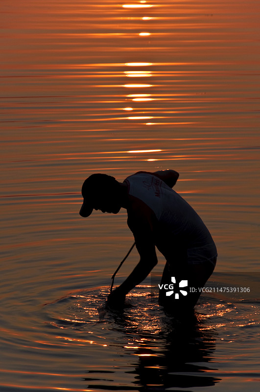 巴西日落时分的钓鱼男子图片素材
