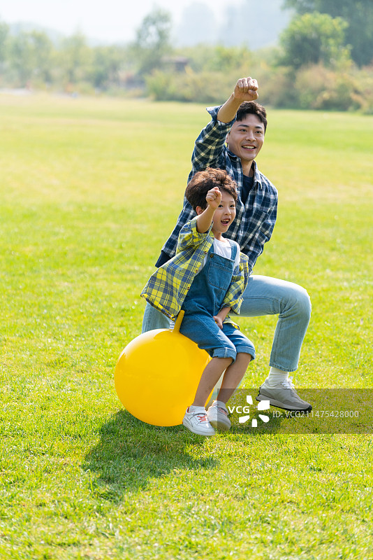 爸爸和儿子在草地上做游戏图片素材
