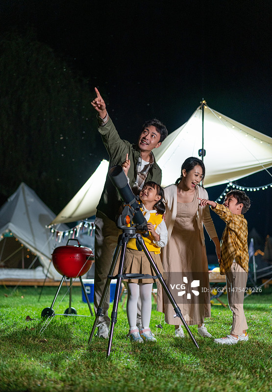 傍晚一家人在露营地用望远镜看星空图片素材