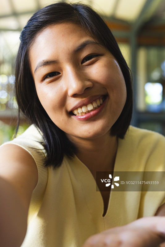 快乐的亚洲短发女子在家视频通话图片素材