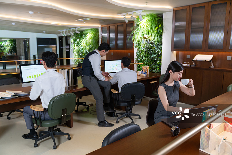 女白领在办公桌前专注看文件喝咖啡图片素材