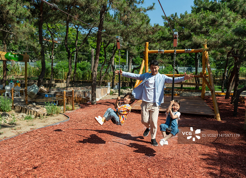 爸爸跟孩子一起开心玩索道图片素材