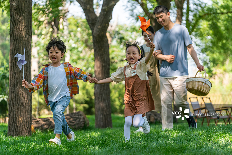 一家四口露营在草地上开心奔跑图片素材