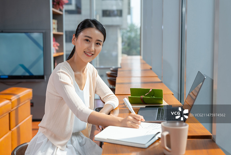 一个年轻人记笔记专注工作图片素材