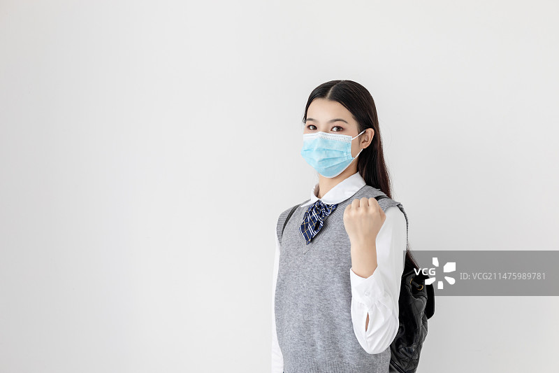 白色背景中一名戴口罩的中国女大学生图片素材