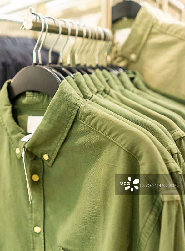 中国商场服装店的生活用品拍摄主题，货架上摆放着悬挂的整齐的衬衣衬衫衣服，室内无人图像摄影图片素材