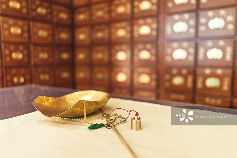 中国中医药服务拍摄主题，中医医院，黄色纸上放着一杆黄色铜制秤和一堆中草药，室内无人图像摄影图片素材