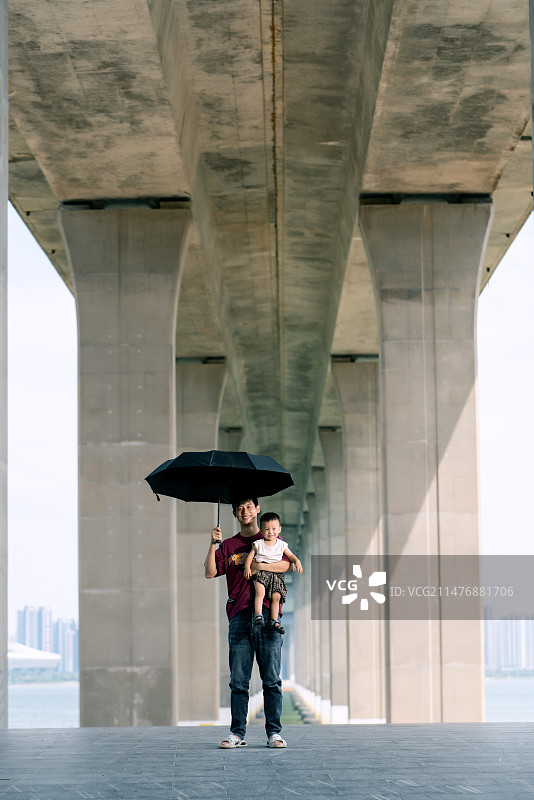 在桥底抱着宝宝的爸爸图片素材