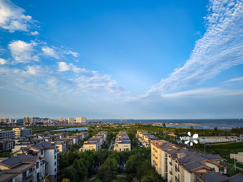 夏天里晴朗的天气，河北秦皇岛南戴河，蓝天白云下碧海边的商品房住宅小区鸟瞰。图片素材