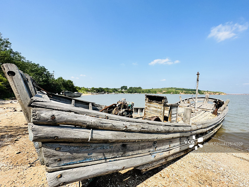 一艘搁浅在海岸边被抛弃的渔船图片素材