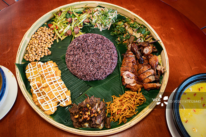 竹簸箕盛装的手抓糯米饭与各种配菜图片素材