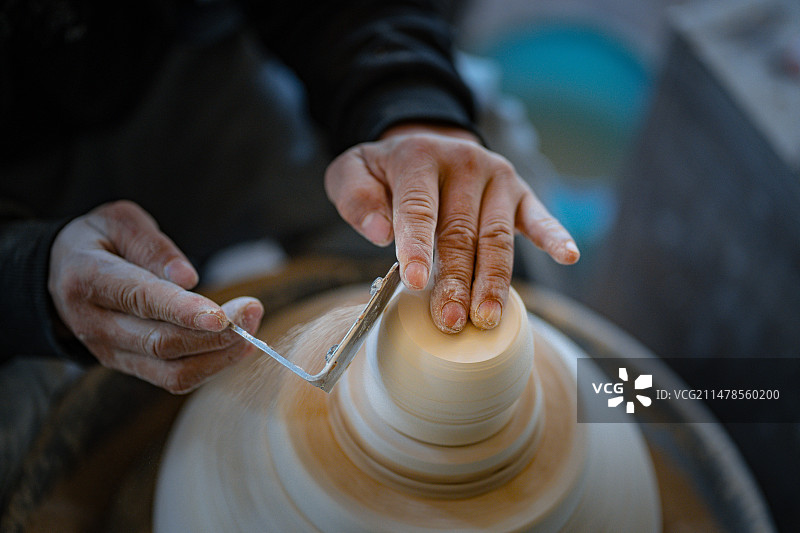 工人在烧制瓷器前进行修坯工作图片素材