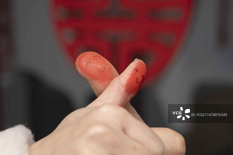 两个沾了印泥画着笑脸的手指图片素材