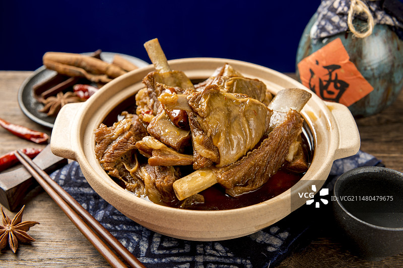 一砂锅红焖羊排摆放在木桌面上特写图片素材