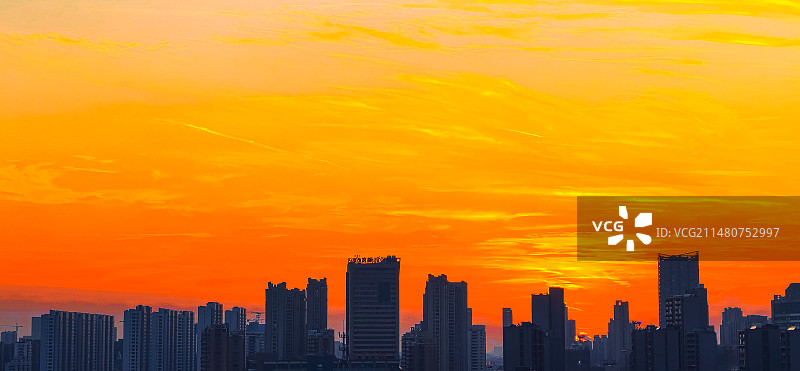 日落时建筑物在多云天空下的轮廓图片素材