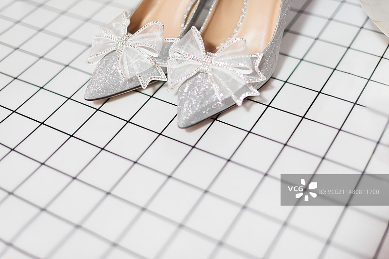 黑白格子上的银色蝴蝶结高跟鞋图片素材