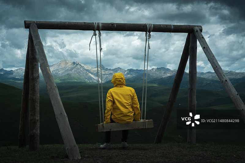 一个人坐在秋千上看川西高原风景图片素材