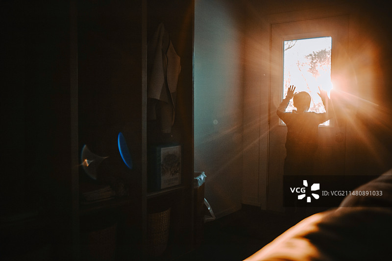 男人透过玻璃门用手机拍摄图片素材