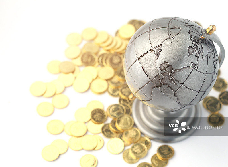 地球仪和金币放在白色背景上图片素材