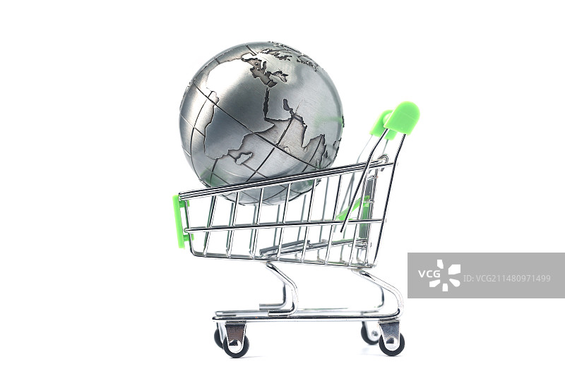 地球仪放在购物车里和硬币在白色背景前图片素材
