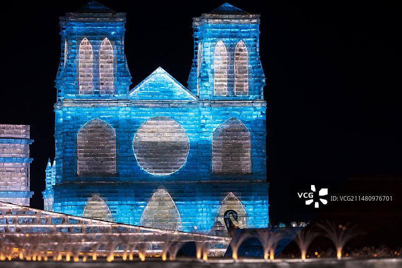 哈尔滨第25届冰雪大世界童话王国景观，地标巴黎圣母院冰雕发出蓝光，中法文化交流，庆祝中法建交60周年图片素材