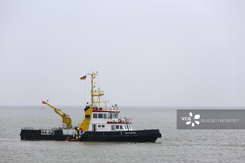 鸟类管理员抵达明斯纳奥格岛,威廉港水运局的浮标层,下萨克森瓦登海国家公园,德国下萨克森州,欧洲图片素材