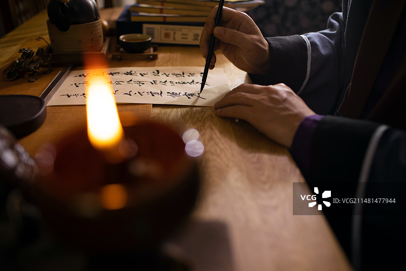 一个古代中医在油灯下开药方局部特写图片素材
