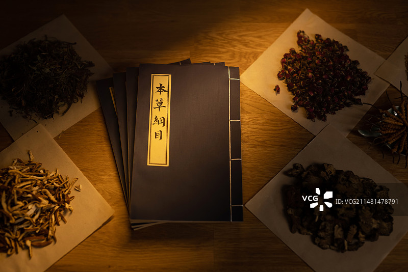 桌子上的本草纲目和中药材,暗色调图片素材