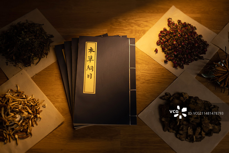 桌子上的本草纲目和中药材,暗色调图片素材