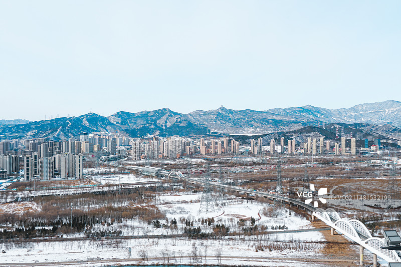 在首钢园功碑阁上拍雪后的北京城市天际线图片素材