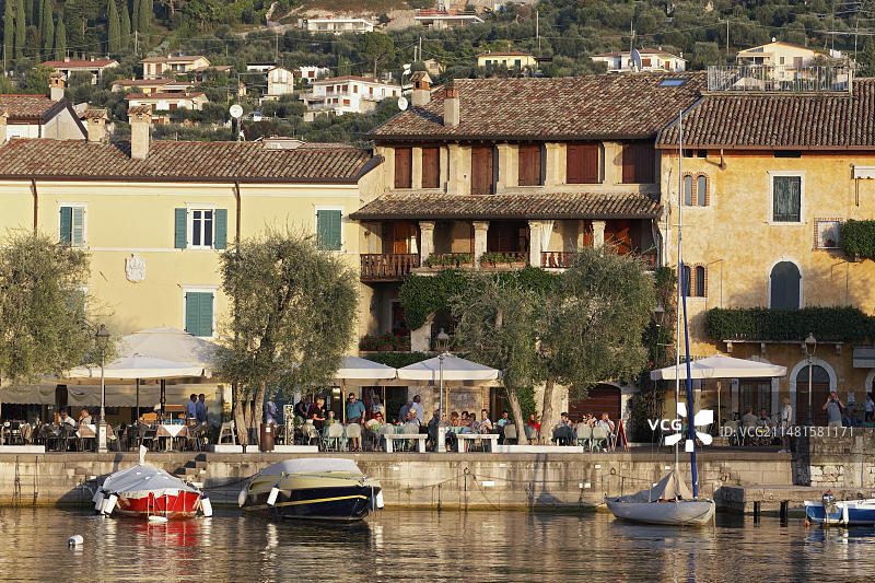 加尔达湖东岸托里德尔贝纳科的湖岸，设有露台餐厅和老城区房屋，位于意大利维罗纳省图片素材