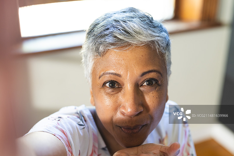 中年混血女人在室内视频通话中飞吻图片素材