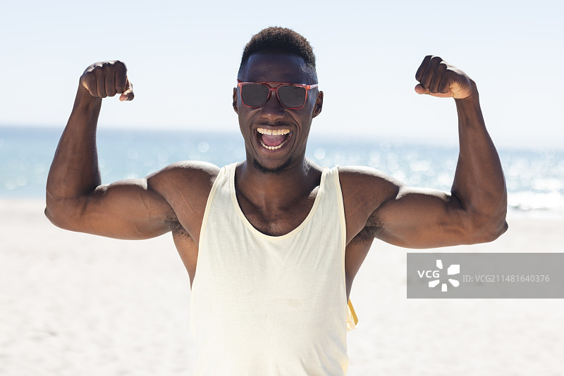 在海滩上展示肌肉的非裔美国男人图片素材