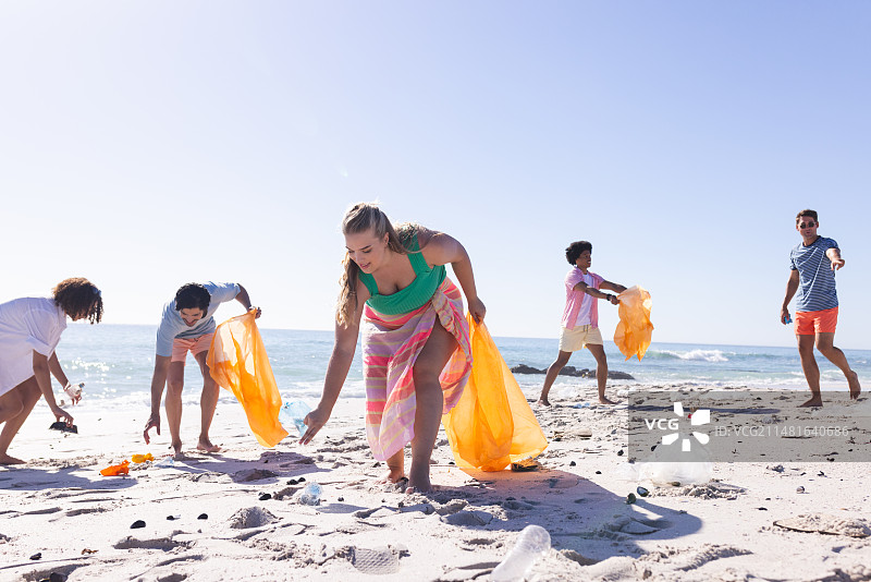 一群朋友在清理海滩并收集垃圾图片素材