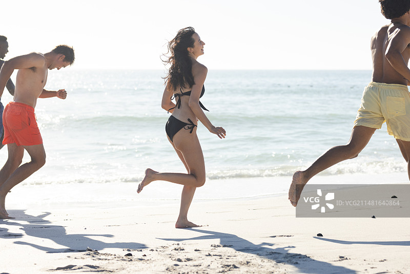 朋友们在海滩上尽情奔跑图片素材