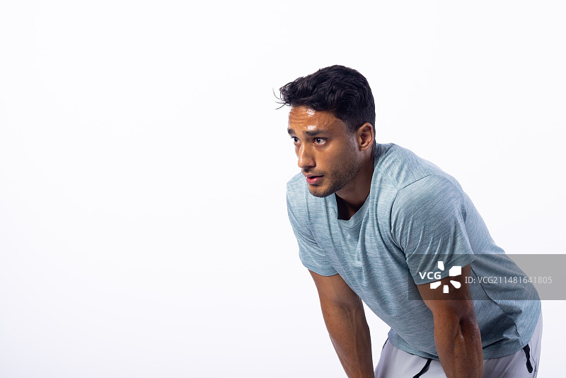 年轻的混血男子锻炼后喘口气，白色背景留有文案空间图片素材