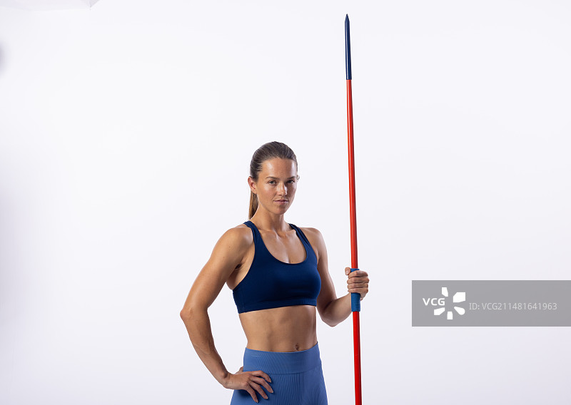 自信年轻白人女运动员持标枪白色背景图片素材
