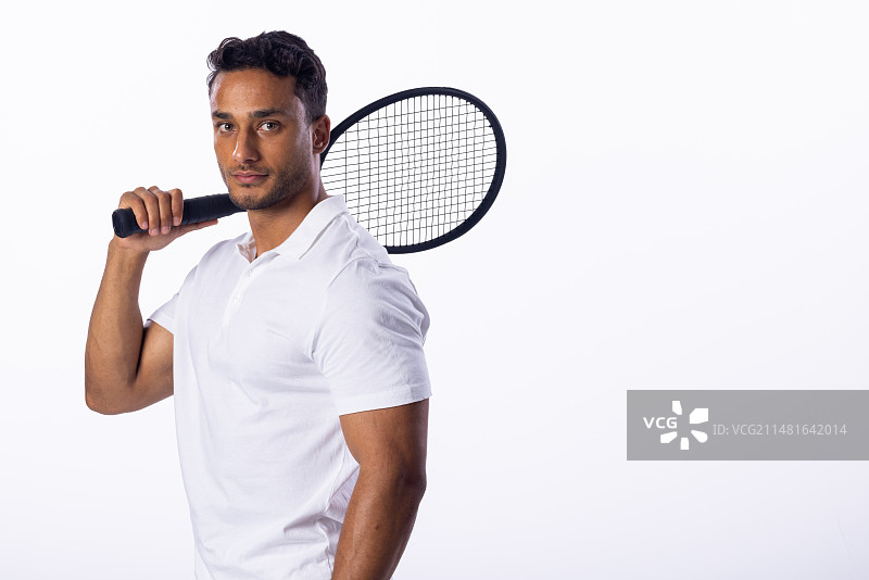 年轻的混血男人在白色背景下手持羽毛球拍图片素材