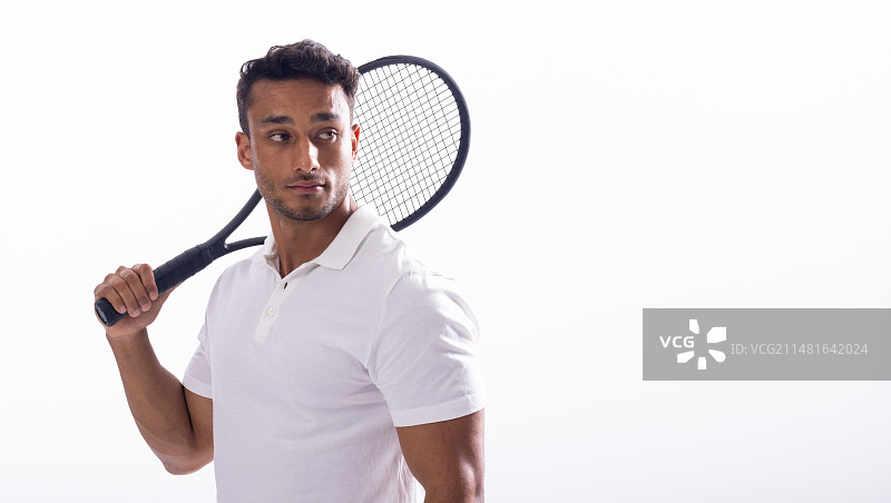 拿着网球拍的年轻混血男人，白色背景，留有文案空间图片素材
