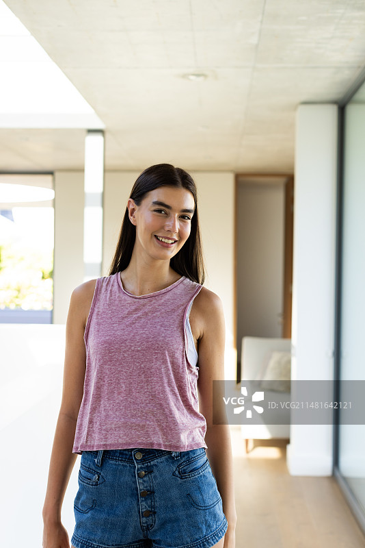 在明亮家居环境中微笑的青少年白人女孩图片素材