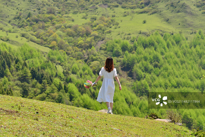 绿水青山，奔跑在草地上的女孩的后视图图片素材