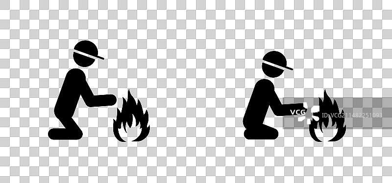 男人坐在篝火旁暖手图片素材