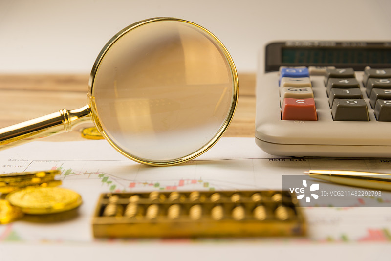 股票金融概念图片：用放大镜观察股票走势图片素材