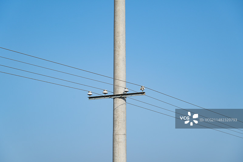 蔚蓝天空下农村旷野中孤独的电线杆图片素材