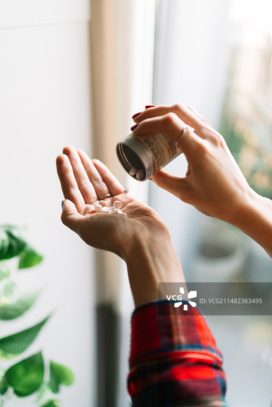 女子在家中手拿药品特写图片素材