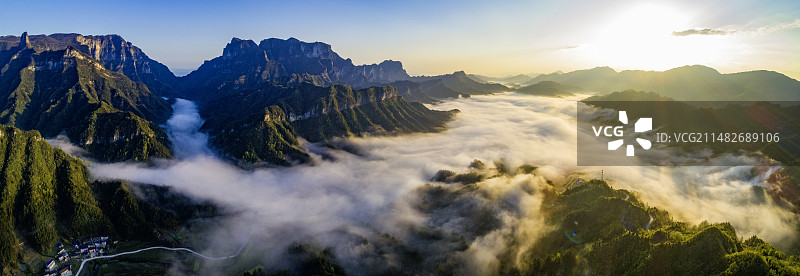 清晨高山下云海茫茫，阳光将云雾涂抹一层金色图片素材