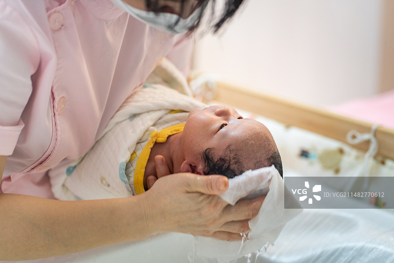 刚出生三天的宝宝,在月子中心洗澡后的护理图片素材