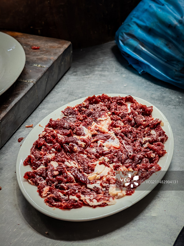 放在白色盆子上的生牛肉图片素材